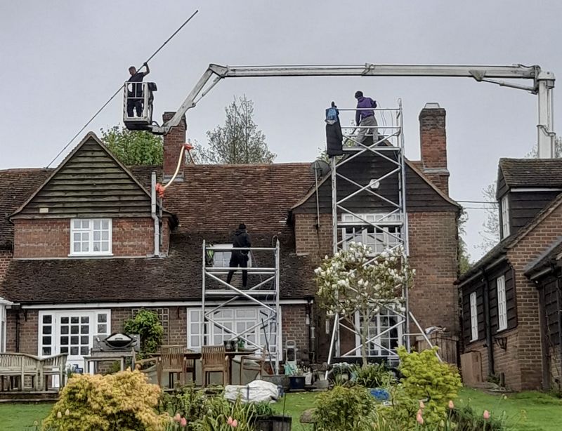 The Roof Moss Cleaners using cherry picker and scaffolding to clean roof safely and professionally in Leatherhead, Surrey